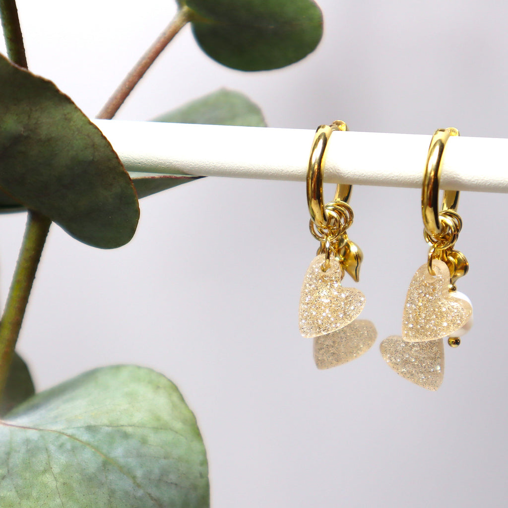 Laadukkaat Edla-rengaskorvakorut huggie-renkailla, makeanveden helmillä ja glittersydämillä