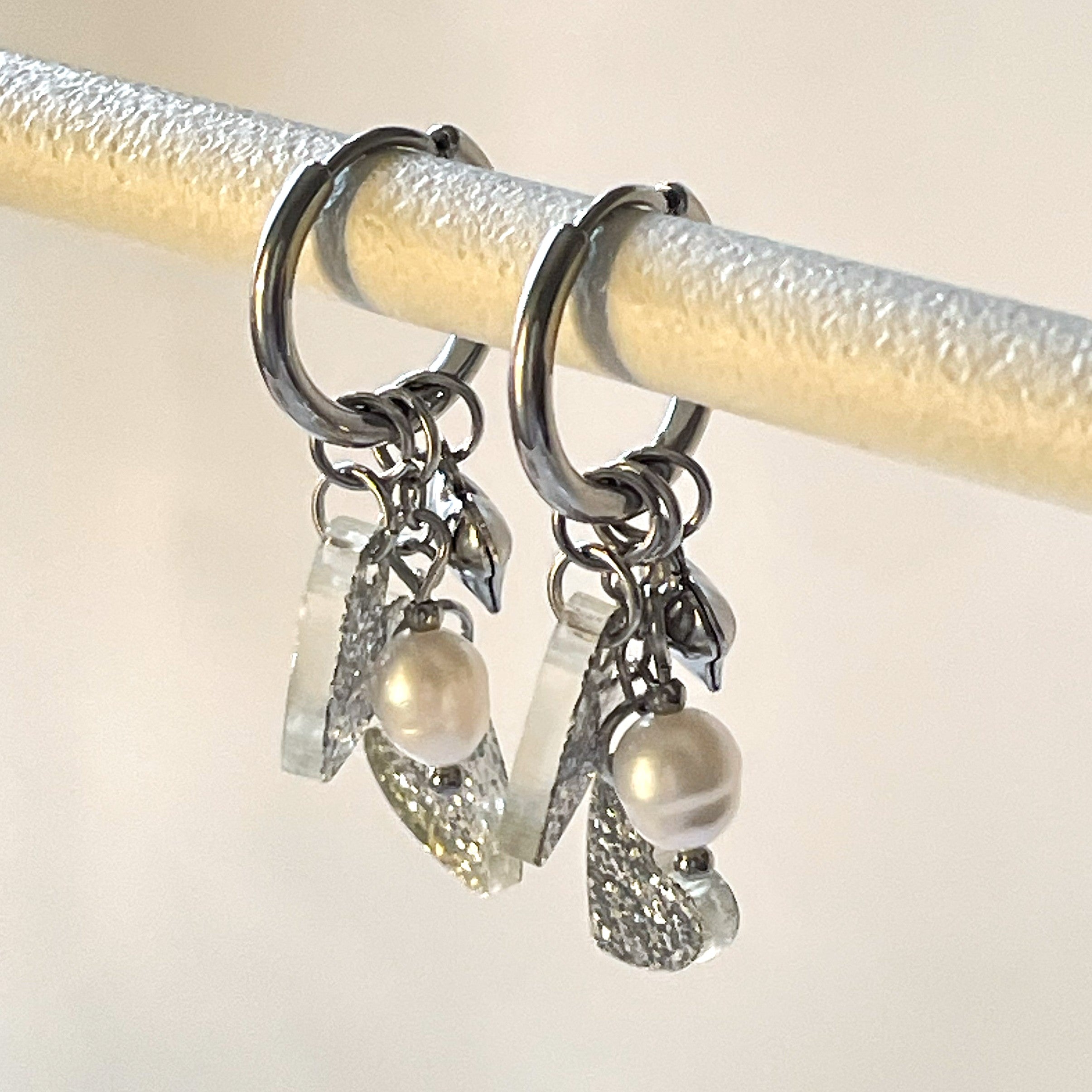 Laadukkaat Edla-rengaskorvakorut huggie-renkailla, makeanveden helmillä ja glittersydämillä