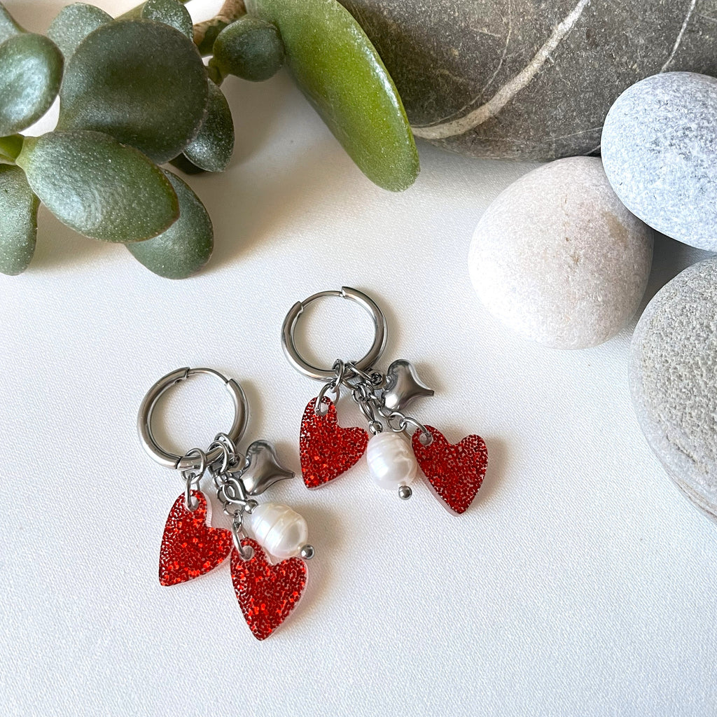 Edla-rengaskorvakorut teräksenvärisillä huggie-renkailla, makeanveden helmillä ja sydänriipuksilla